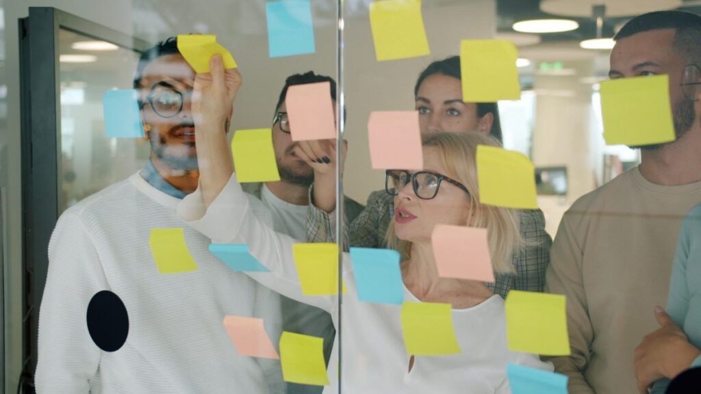 A team planning with sticky notes on a glass wall